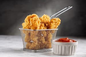 Golden-brown breaded chicken strips, also known as chicken fingers, served hot and crispy at Brendel’s Bagels in Long Island, NY.