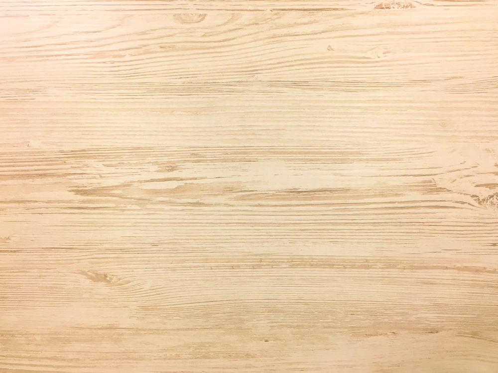 Light wood texture background with visible grain patterns and knots. The surface is smooth and evenly colored, showcasing natural wood tones in shades of beige and light brown—the perfect backdrop for any catering company in Long Island, NY to set the stage for a delightful dining experience.